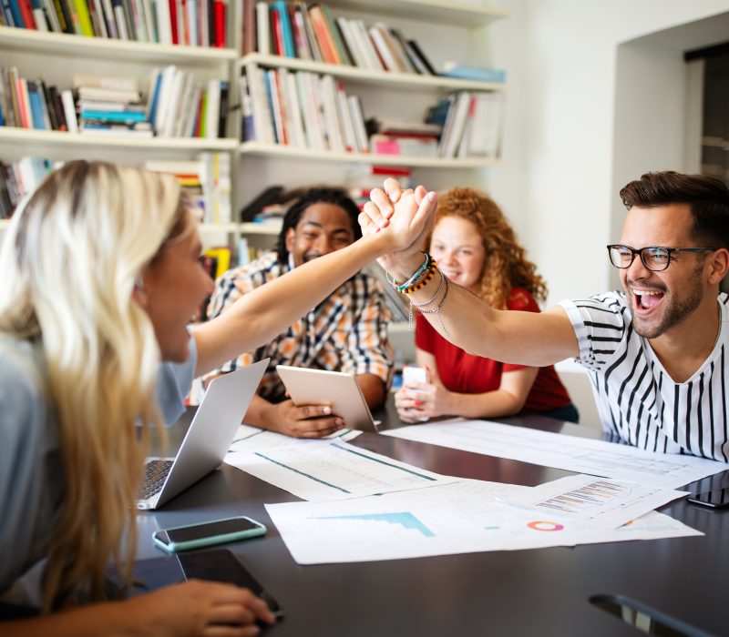 Group of successful happy business people in office celebrating profits Group of successful business people in office celebrating profits and team building
